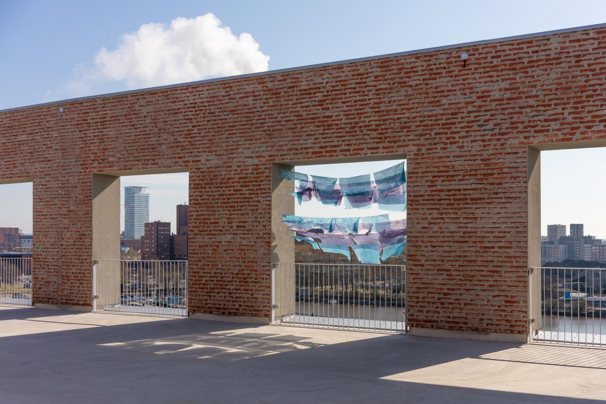 A terrace with large window openings surrounded by brick walls.